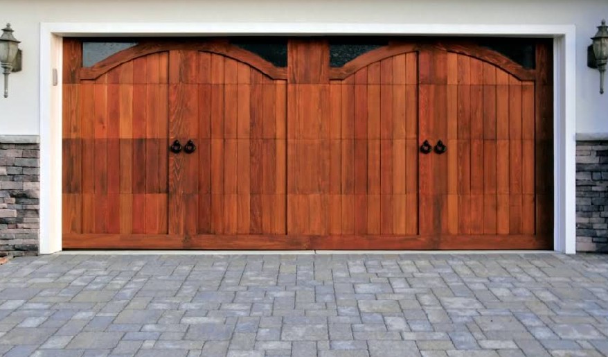 High-end wooden double garage doors with classic arched top windows.