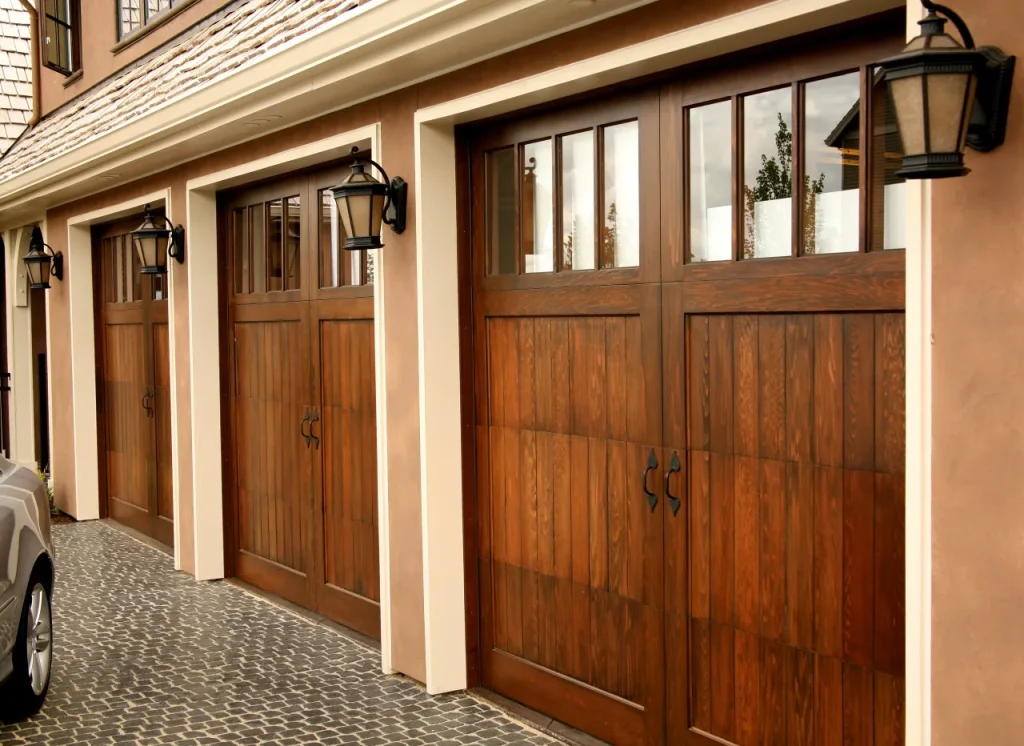 Custom wooden double garage doors with vertical panels and upper windows.