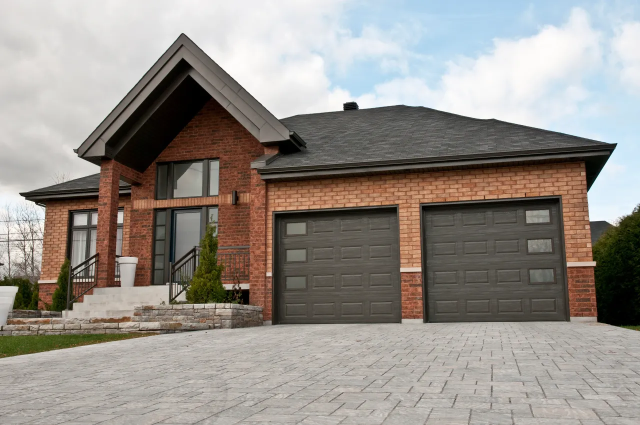 Modern home exterior showcasing a new dark grey garage door installation.