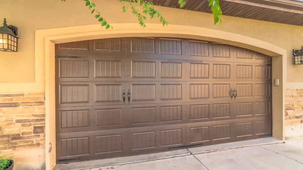 Wooden carriage-style garage door with top windows.